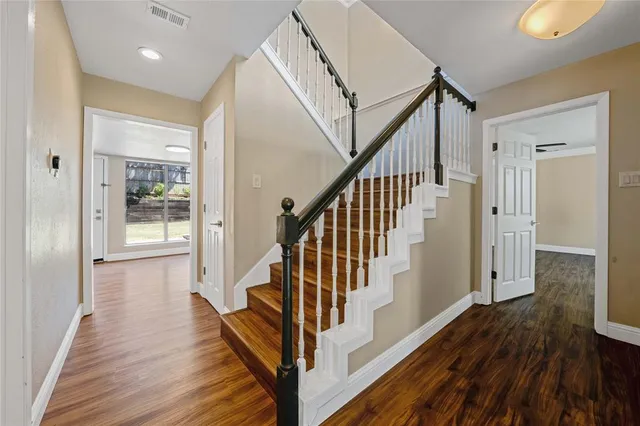 a view of a hallway with wooden floor and staircase