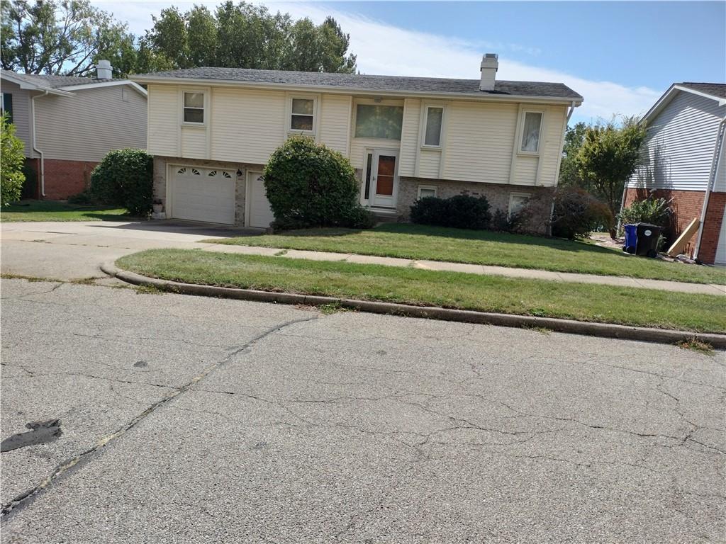 a view of a house with a backyard and a garage