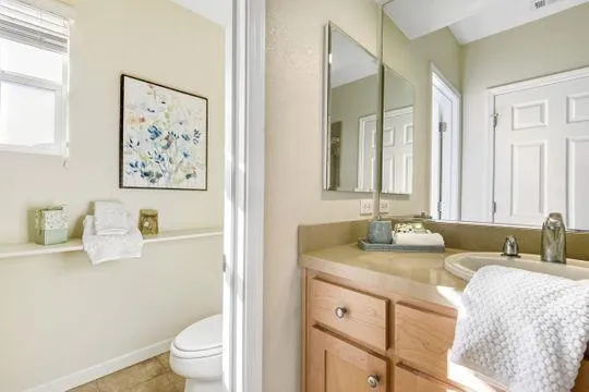a bathroom with a granite countertop sink mirror vanity and toilet