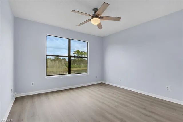 an empty room with a window and a fan