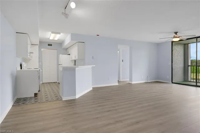 a view of empty room with wooden floor and windows