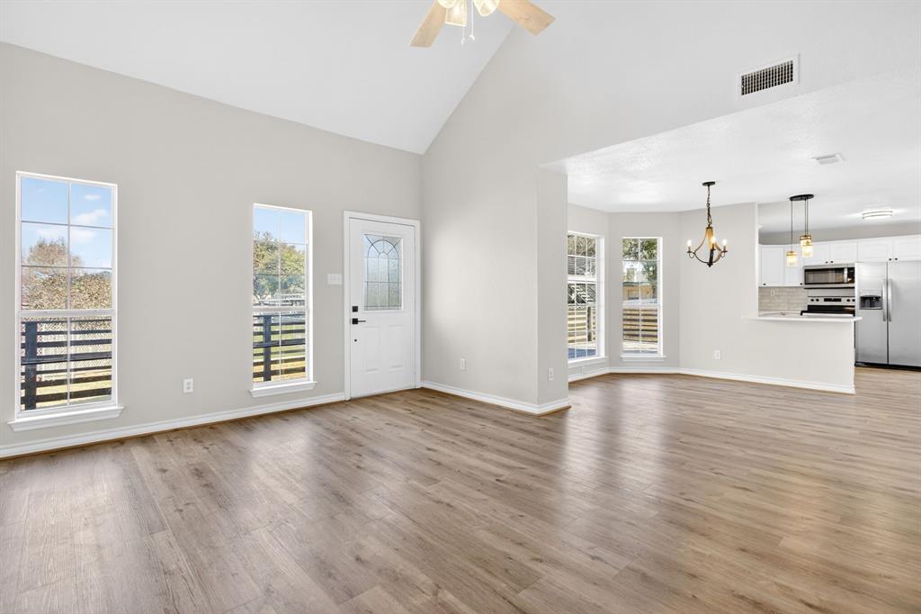 4309 Davis Road Granbury, TX 76049 - Photo 14 of 40 an empty room with wooden floor cabinet and windows