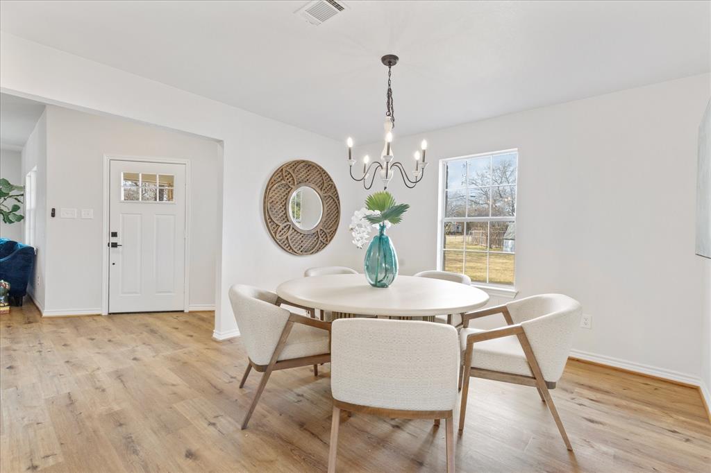4309 Davis Road Granbury, TX 76049 - Photo 22 of 40 a view of a dining room with furniture a chandelier and wooden floor