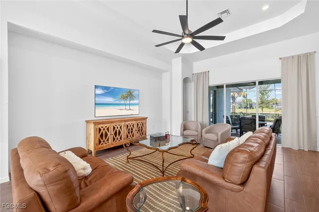 a living room with furniture a ceiling fan and a window