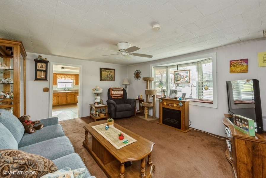 6002 Pine Street Harvard, IL 60033 - Photo 4 of 21 a living room with furniture a window and a flat screen tv