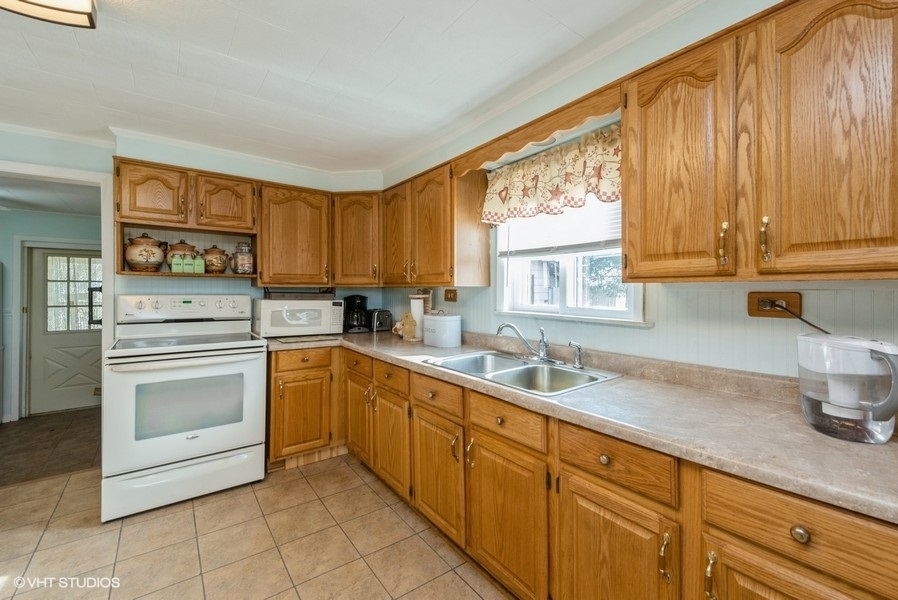 6002 Pine Street Harvard, IL 60033 - Photo 6 of 21 a kitchen with granite countertop a sink stainless steel appliances and cabinets