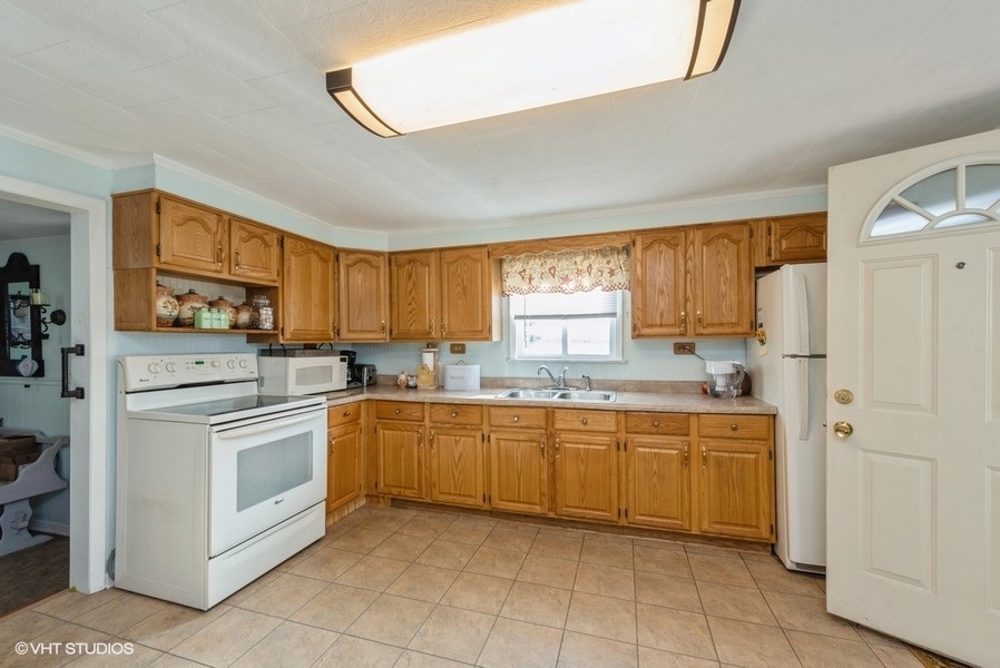 6002 Pine Street Harvard, IL 60033 - Photo 8 of 21 a kitchen with white cabinets and white appliances