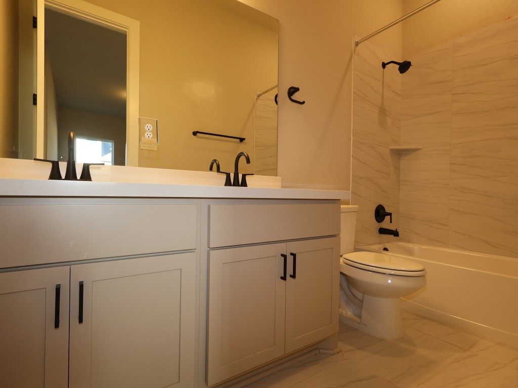 374 Bishop Wood Road Dripping Springs, TX 78620 - Photo 11 of 18 a bathroom with a sink a toilet and mirror