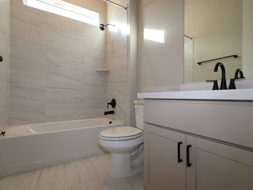 374 Bishop Wood Road Dripping Springs, TX 78620 - Photo 16 of 18 a bathroom with a sink a toilet and shower