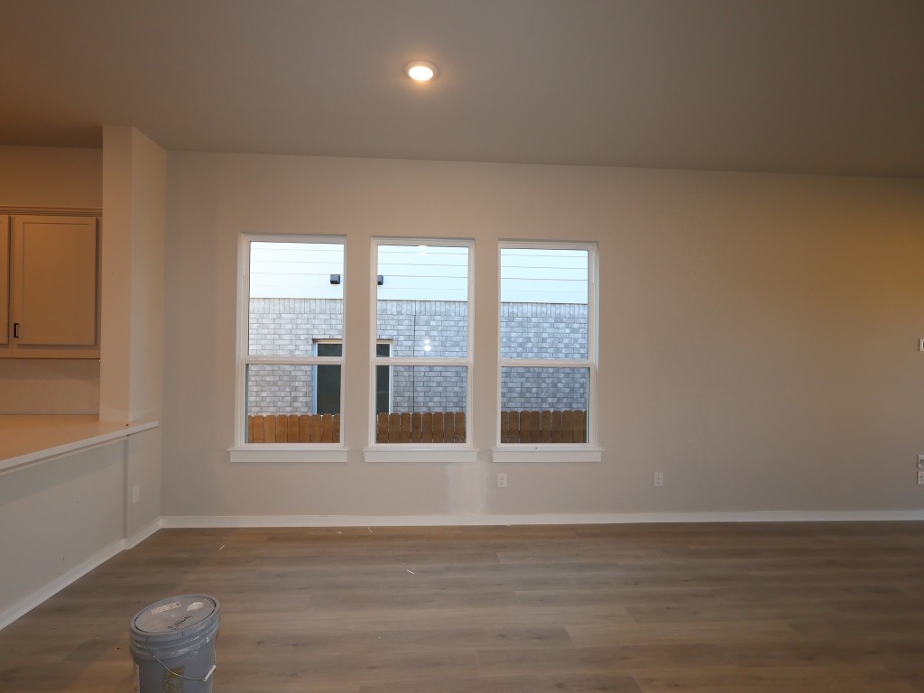 374 Bishop Wood Road Dripping Springs, TX 78620 - Photo 3 of 18 a view of an empty room with wooden floor and a window