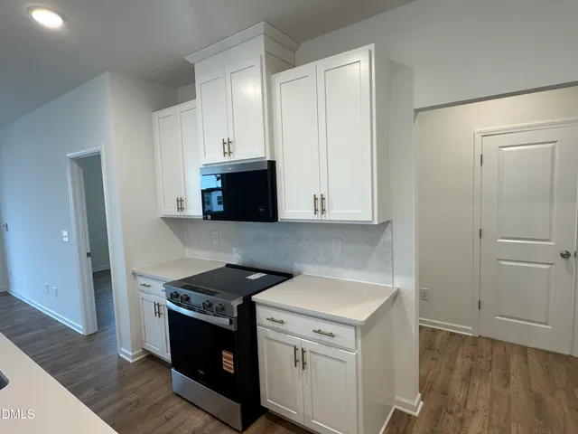 a kitchen that has a sink a window and wooden floor