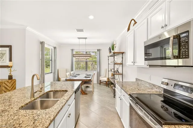 a kitchen with stainless steel appliances granite countertop a sink dishwasher stove and refrigerator