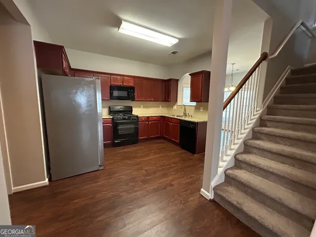 a kitchen with stainless steel appliances granite countertop a refrigerator and a stove top oven
