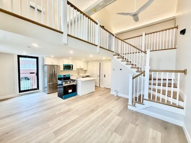 a living room with stairs and a wooden floor
