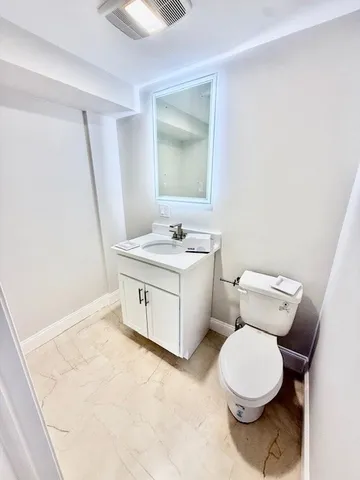 a bathroom with a toilet sink and mirror