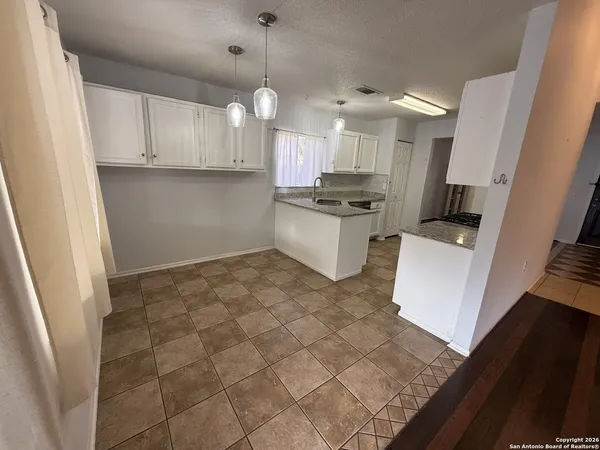 a large kitchen with white cabinets and stainless steel appliances