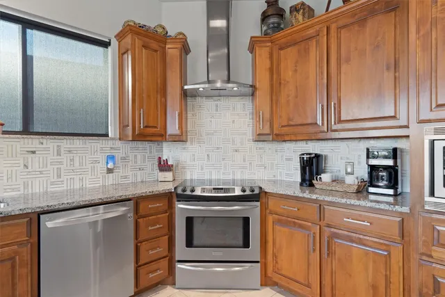 a kitchen with granite countertop a sink stainless steel appliances and cabinets