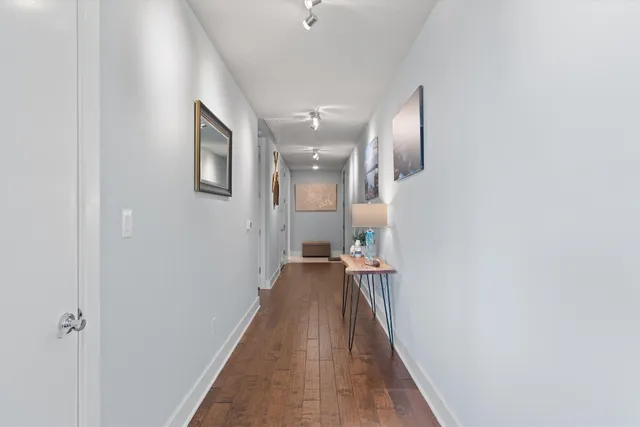 a view of a hallway with wooden floor and staircase