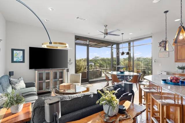 a living room with furniture a flat screen tv and a large window
