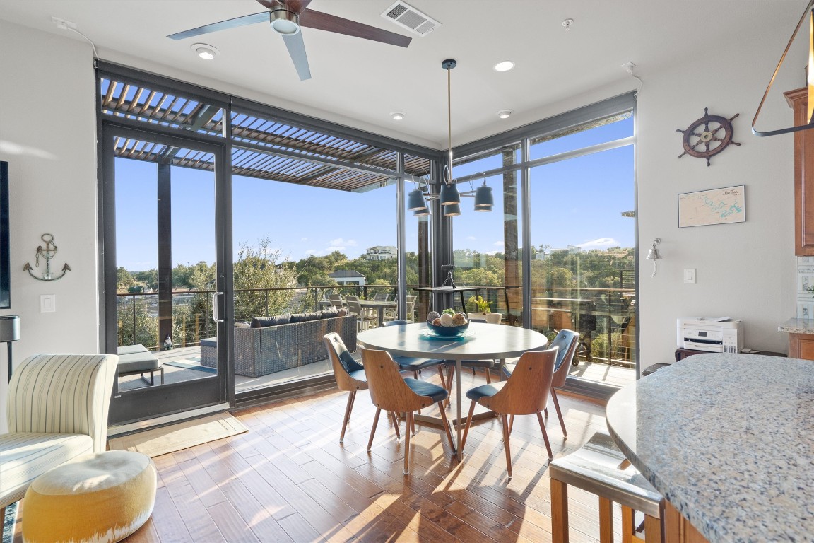 1101 Ivean Pearson Road, Unit E208 Lago Vista, TX 78645 - Photo 10 of 40 a view of a dining room with furniture large windows and wooden floor