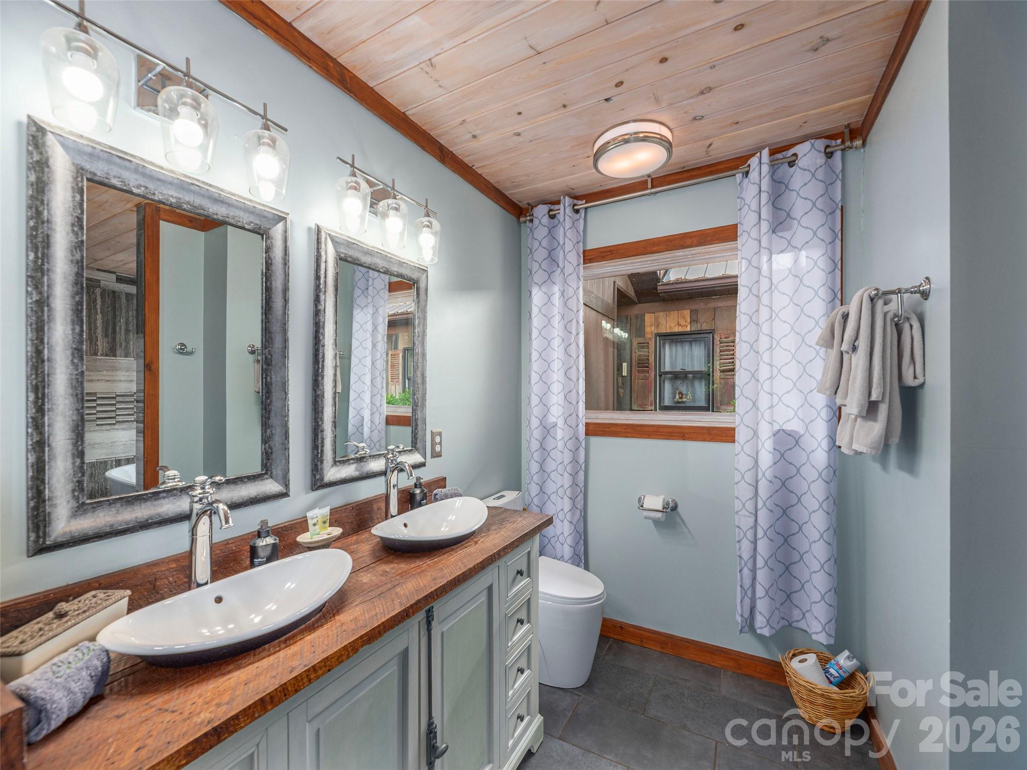 461 Ferguson Cove Loop Clyde, NC 28721 - Photo 22 of 46 a bathroom with a granite countertop sink and a mirror