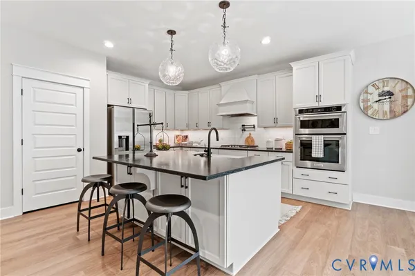a kitchen with stainless steel appliances a stove a refrigerator and a microwave