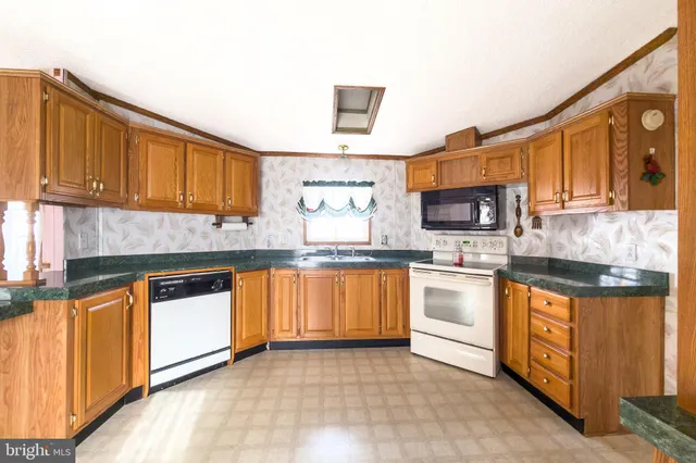 a kitchen with stainless steel appliances granite countertop a stove sink and cabinets