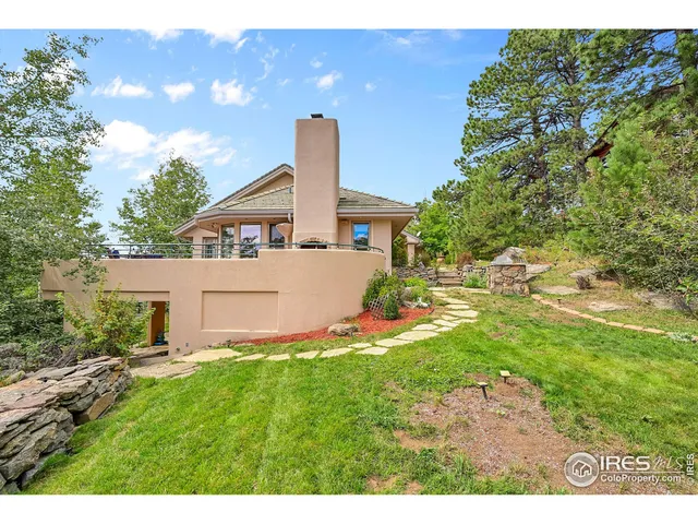 a view of an house with backyard and a tree