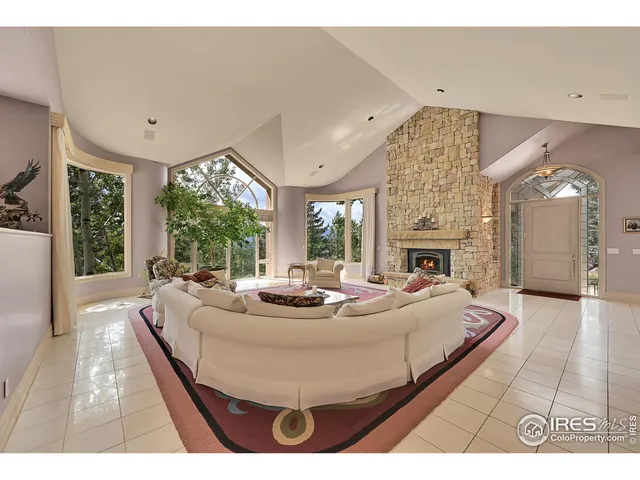 a living room with fireplace furniture and a large window