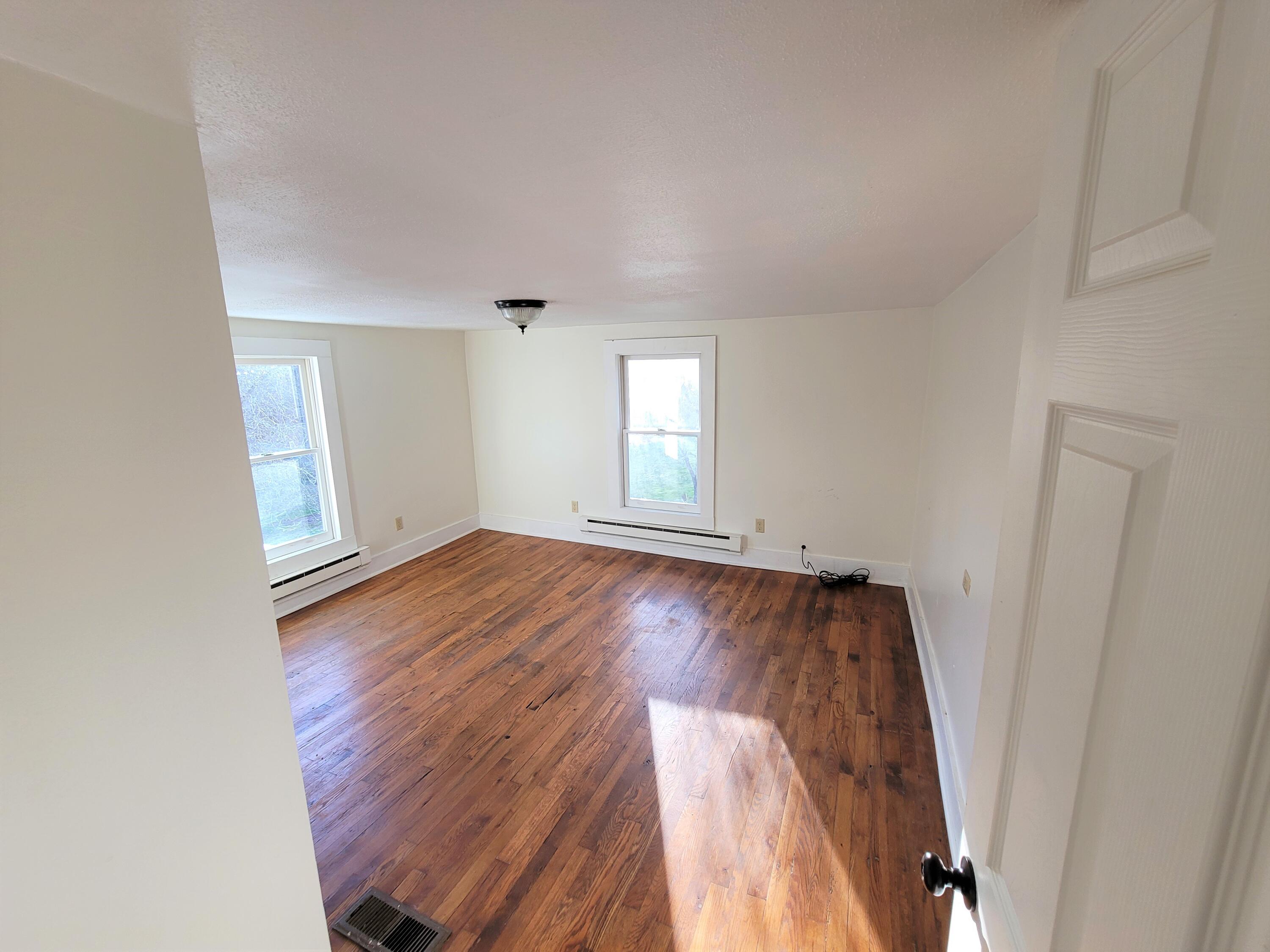 330 Green Level Road Boones Mill, VA 24065 - Photo 26 of 43 an empty room with wooden floor and windows