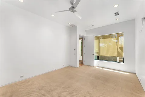 an empty room with a fireplace and windows