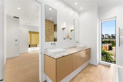a bathroom with a tub a sink and mirror