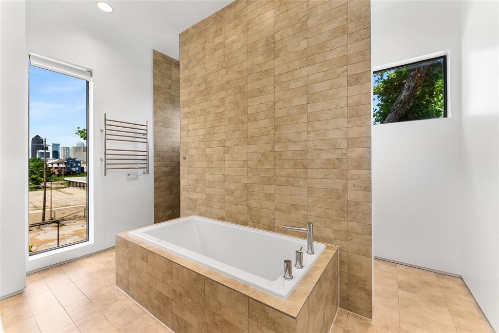 1505 North Haskell Avenue, Unit 5 Dallas, TX 75204 - Photo 24 of 40 a bath tub sitting in a bathroom next to a window