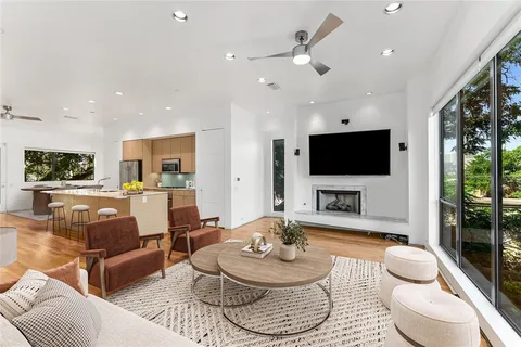 a living room with furniture a flat screen tv and a large window