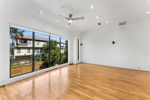 an empty room with wooden floor and windows