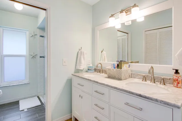 a bedroom with a bed a chandelier and a window