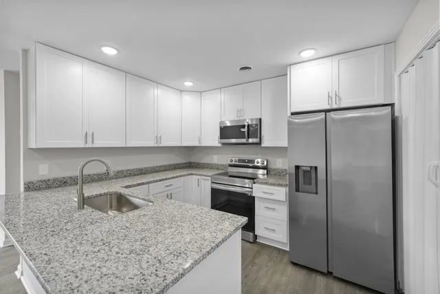 a kitchen with a sink a refrigerator and cabinets