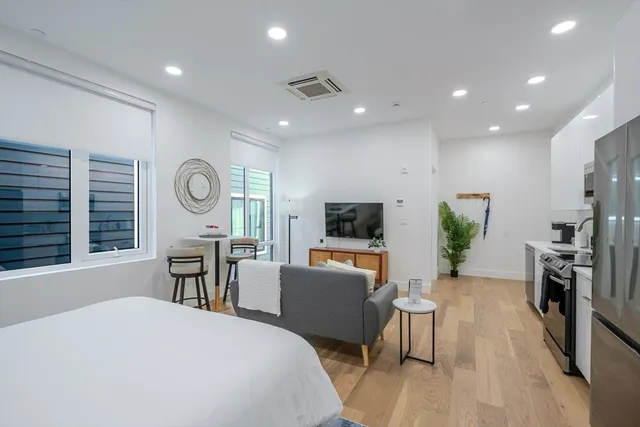 a living room with furniture a fireplace a flat screen tv and a window