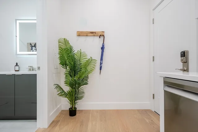 a view of a hallway with wooden floor and a potted plant