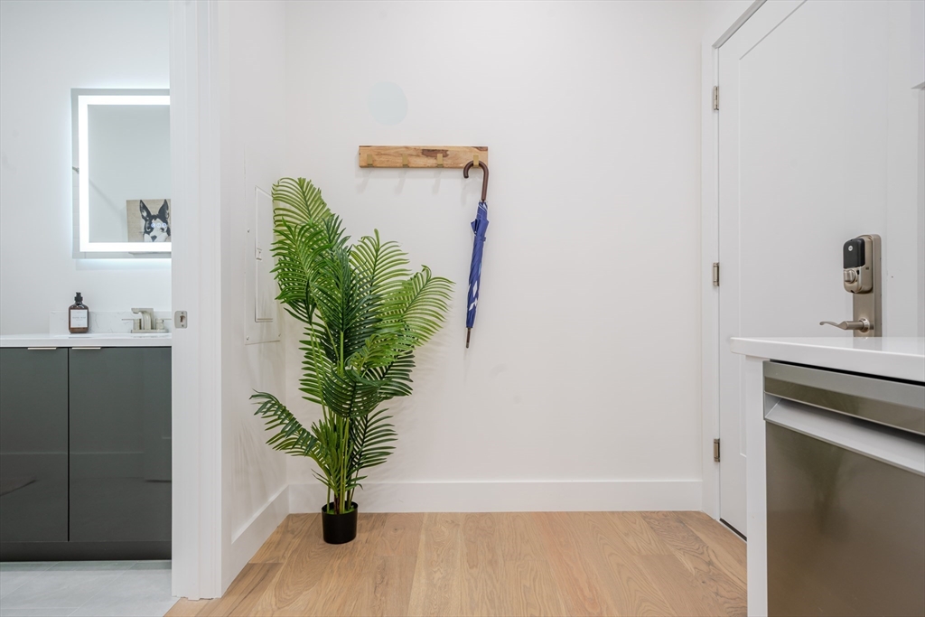 38 Hichborn Street, Unit 404FURNISHE Boston, MA 02135 - Photo 15 of 16 a view of a hallway with wooden floor and a potted plant