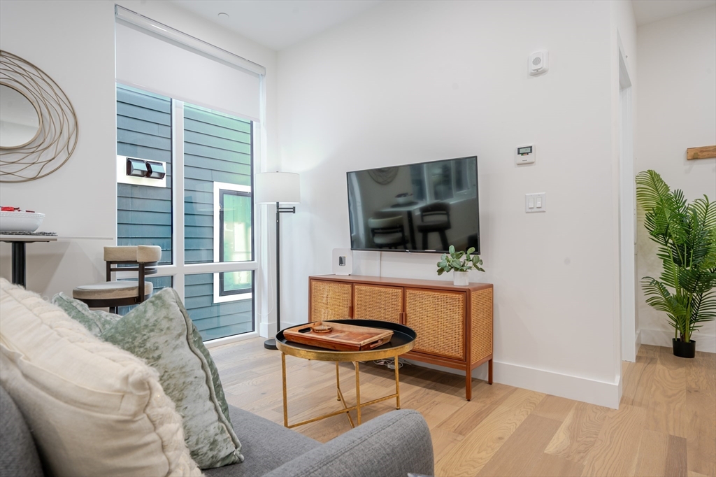 38 Hichborn Street, Unit 404FURNISHE Boston, MA 02135 - Photo 3 of 16 a living room with furniture and a flat screen tv