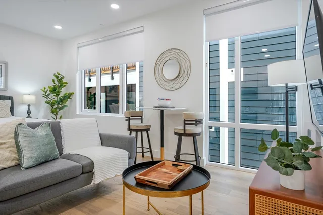 a living room with furniture a chandelier and a window
