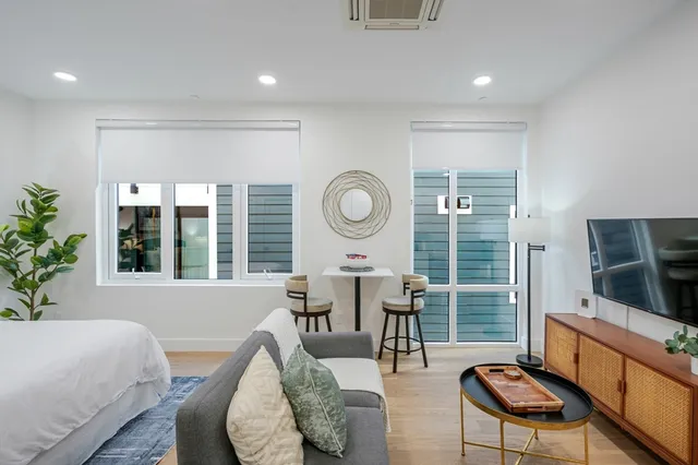 a living room with furniture a flat screen tv and a large window