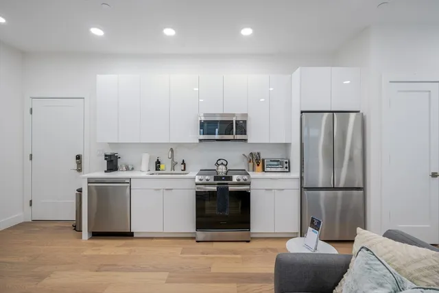 a kitchen with stainless steel appliances granite countertop a refrigerator sink and stove