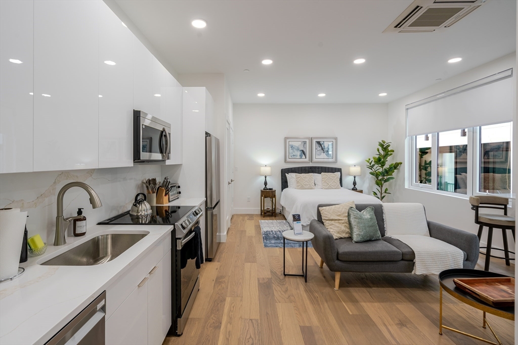 38 Hichborn Street, Unit 404FURNISHE Boston, MA 02135 - Photo 9 of 16 a bedroom with a bed a couch and dresser