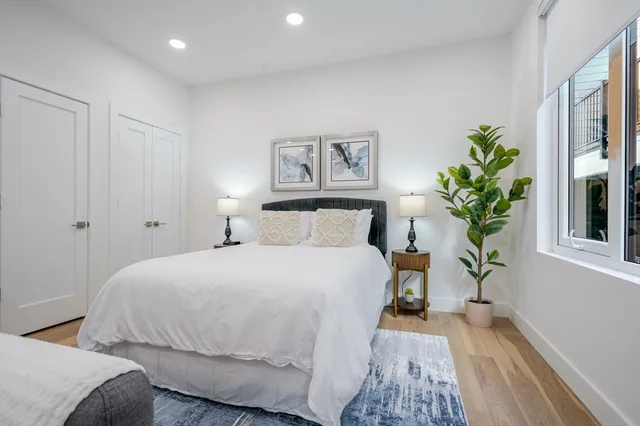 a bedroom with a large bed and a potted plant
