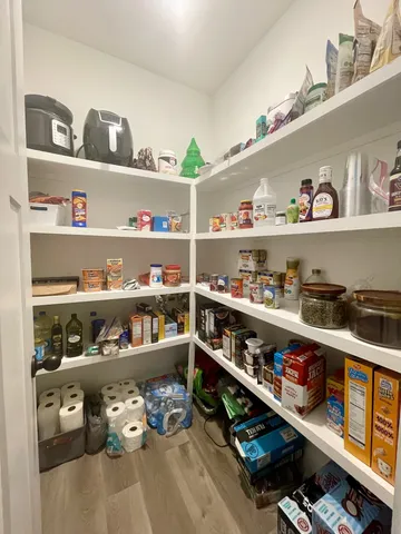 a cabinet with granite countertop lots of different kinds of food
