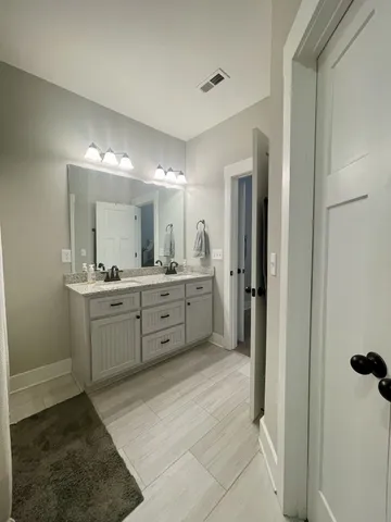 a large bathroom with a double vanity sink mirror and toilet