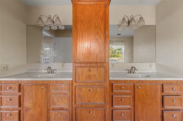 a bathroom with a granite countertop sink a mirror and cabinets