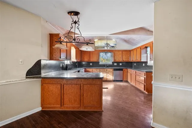 a kitchen with stainless steel appliances granite countertop wooden floors and granite counter tops
